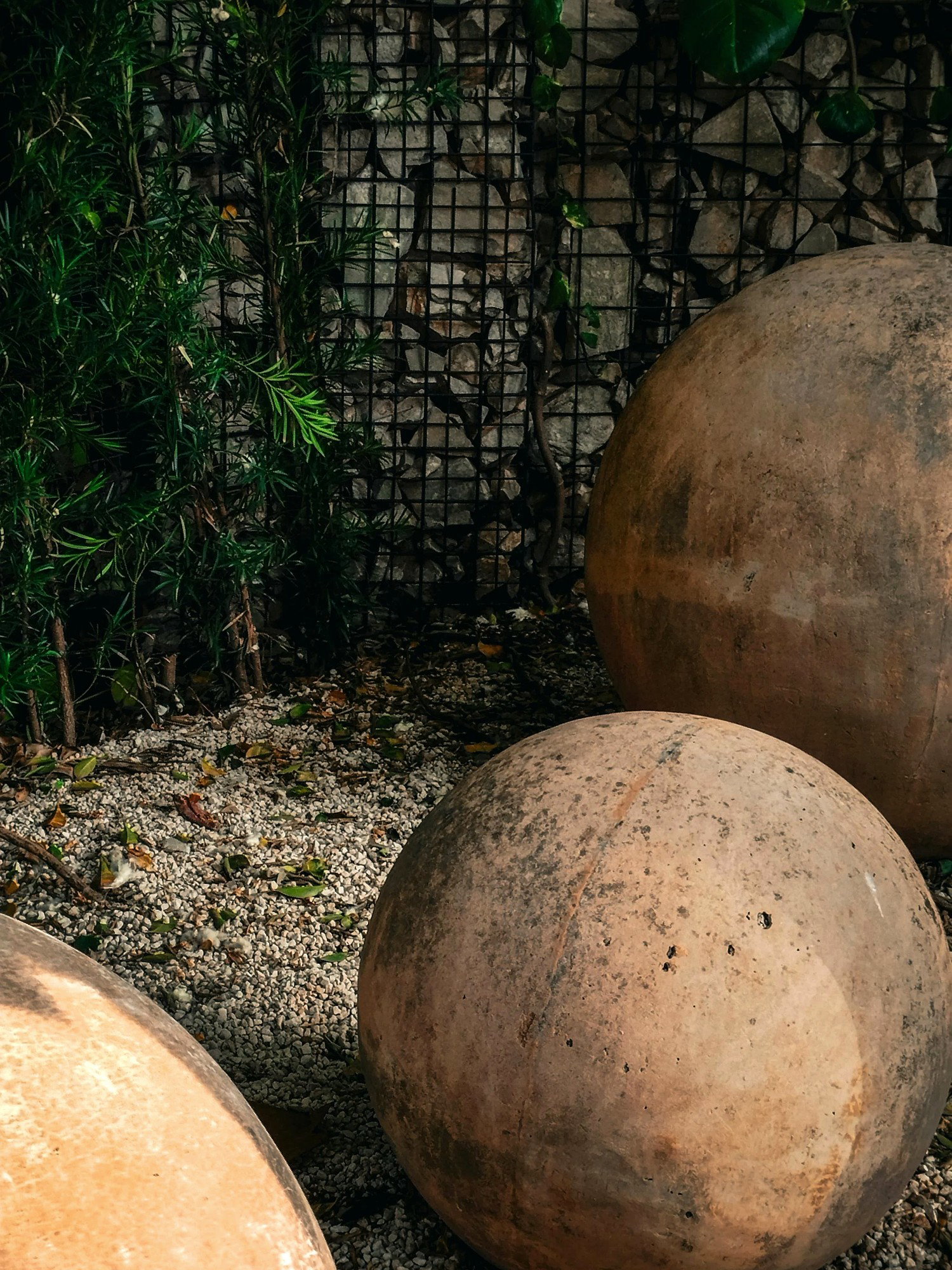 Ultra realistic cast stone orbs in a garden with mineral wall texture