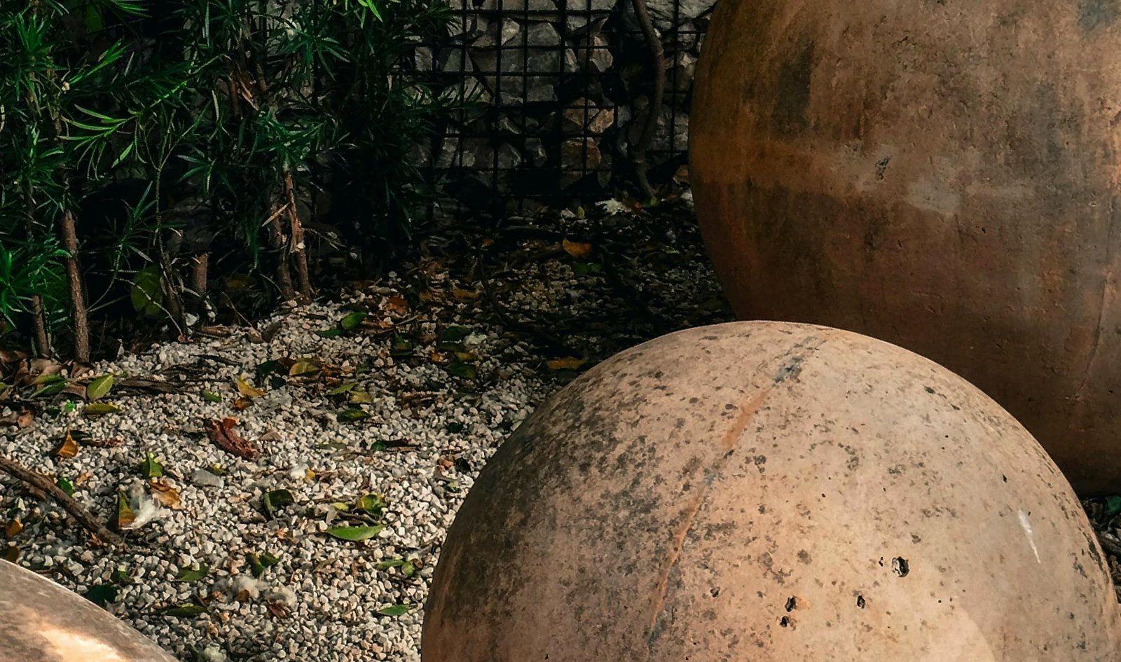 Wide cast-stone orb garden with gravel and green texture
